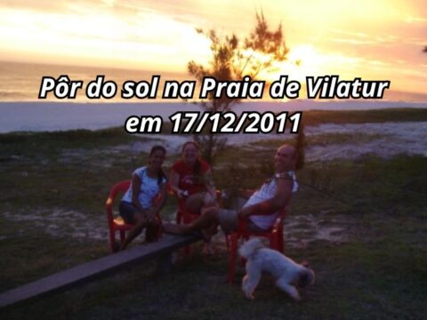 O Espetáculo do Fim de Tarde: A Magia Atemporal do Pôr do Sol na Praia de Vilatur Pôr do sol dourado e alaranjado refletido nas ondas da Praia de Vilatur em Saquarema, visto a partir da sacada de uma pousada à beira-mar.